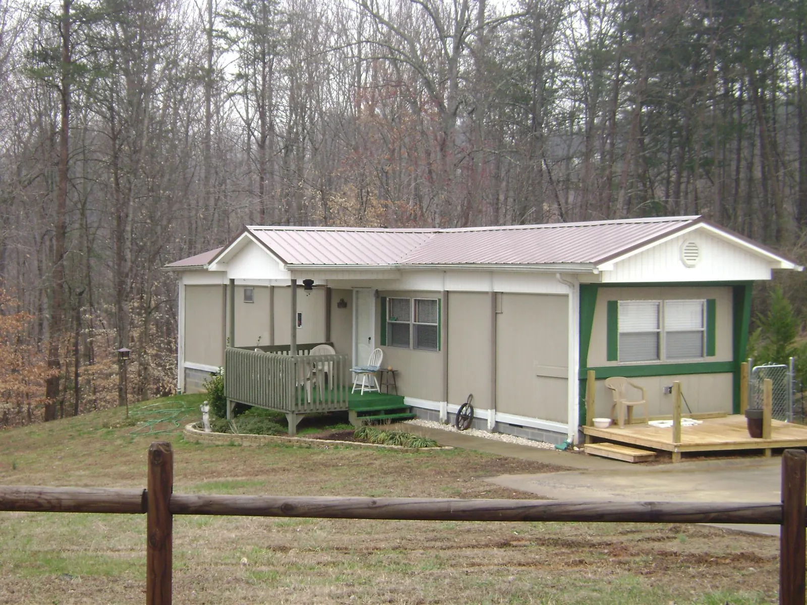 Mauve metal roof on a manufactured home with a new front deck in New Liberty